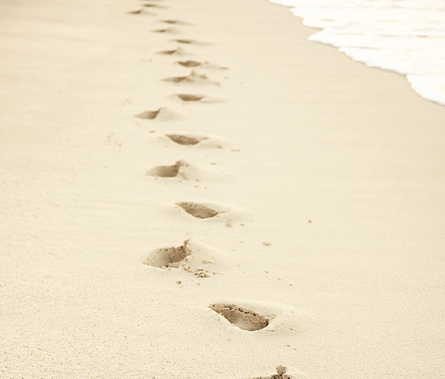 Embark on a Journey - footsteps on the beach leading to freedom